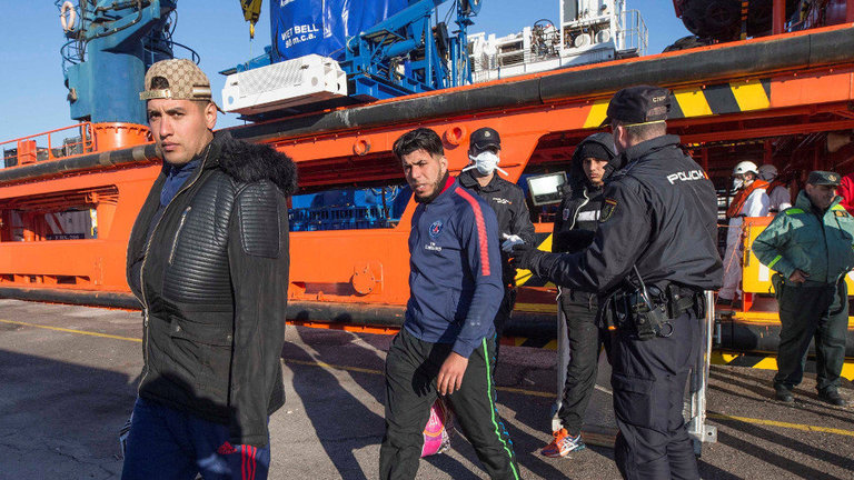 Agentes de policía nacional custodian el desembarco de los 48 inmigrantes argelinos rescatados el lunes en aguas de Cartagena. MARCIAL GUILLÉN (EFE)