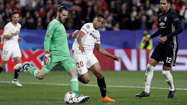 El delantero del Sevilla Luis Muriel pelea un balón con el portero del United David de Gea. JOSÉ MANUEL VIDAL (EFE)