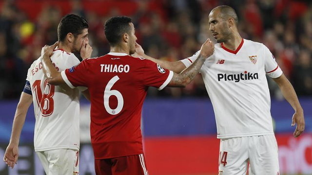 Los jugadores del Sevilla Guido Pizarro (d) y Sergio Escudero (i) saludan a Thiago Alcántara, del Bayern. JOSÉ MANUEL VIDAL (EFE)