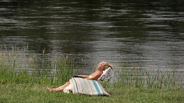 Una mujer disfruta de las agradables temperaturas en la zona fluvial del río Miño. BRAIS LORENZO