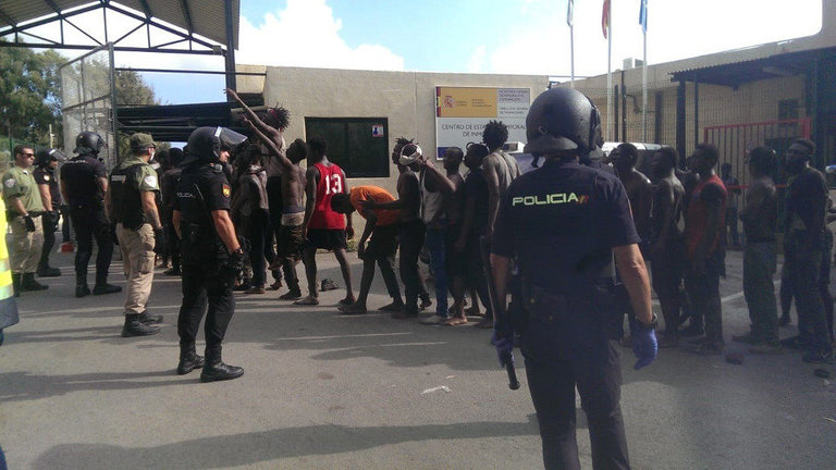 Varios de los inmigrantes esperan su entrada al CETI de Ceuta tras conseguir saltar la valla fronteriza. JOSÉ M. RINCÓN (EFE)