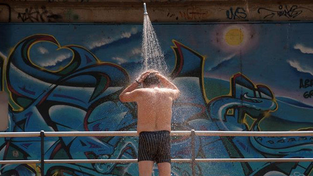 Un home refréscase nunha ducha instalada na praia fluvial da Antena de Ourense. BRAIS LORENZO (EFE)