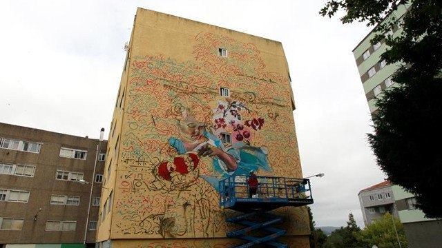 La primera artista comenzó ya un mural de gran formato en uno de los edificios del barrio de Canido en Ferrol. KIKO DELGADO (EFE)