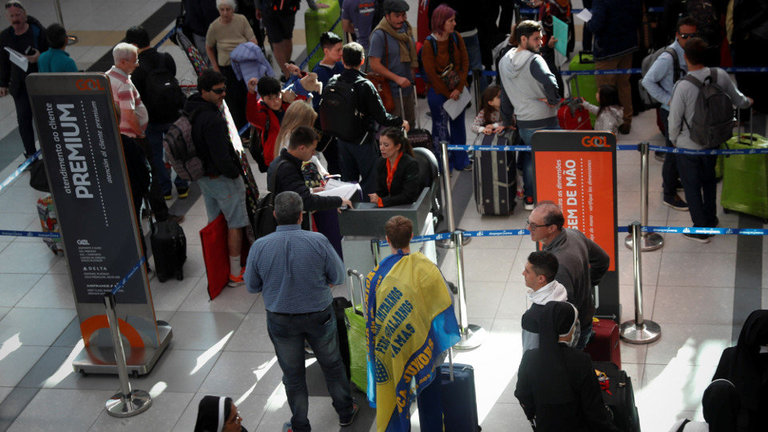 Hinchas del Boca Juniors y River Plate esperan en el Aeropuerto Internacional de Ezeiza para viajar a Madrid. JUAN IGNACIO RONCORINI (EFE)