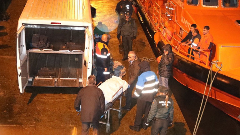 Momento en el que uno de los cadáveres es desembarcado en Porto do Son. PEPE FERRÍN (AGN)