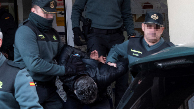 Bernardo Montoya abandonando la Comandancia de la Guardia Civil de Huelva entre los gritos de indignación de decenas de vecinos. JULIÁN PÉREZ (EFE)