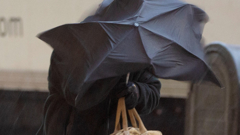 Una persona se cubre con un paraguas en pleno temporal de viento y lluvia. AEP