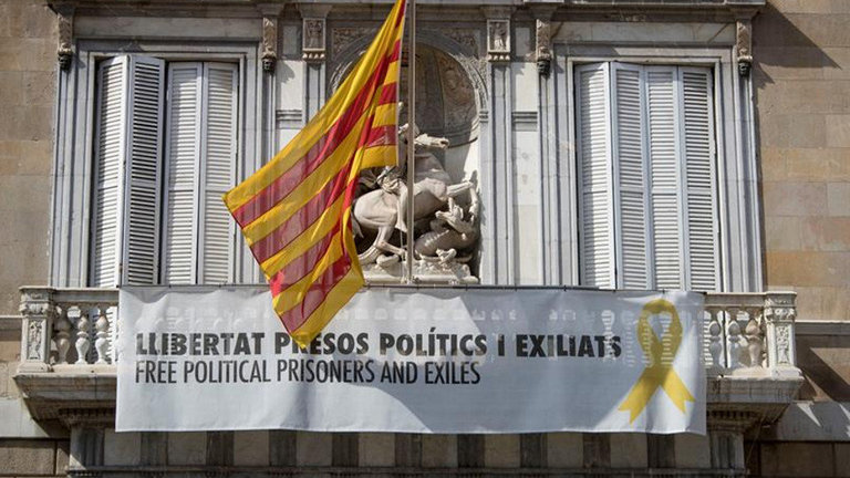 Fachada del Palau de la Generalitat con un cartel y un lazo amarillo reivindicando la libertad de los políticos encarcelados. EFE