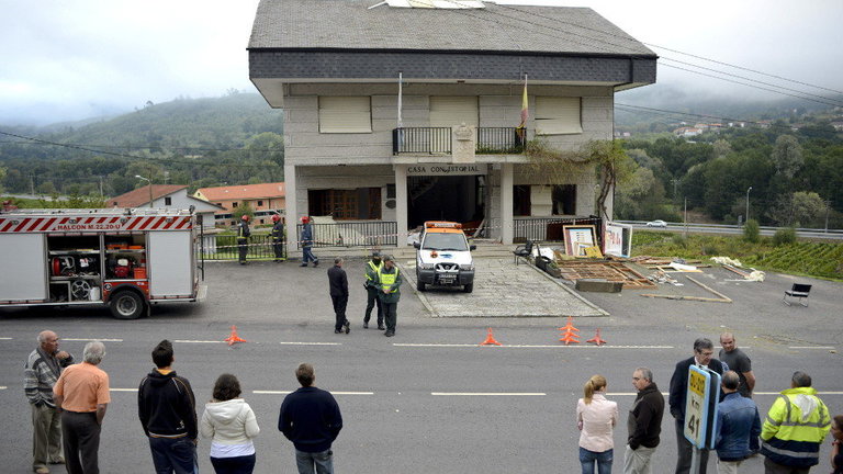 Un grupo de vecinos frente al Ayuntamiento de la localidad orensana de Beade, tras la explosión de un artefacto colocado en la puerta del consistorio en 2013. BRAIS LORENZO (EFE)