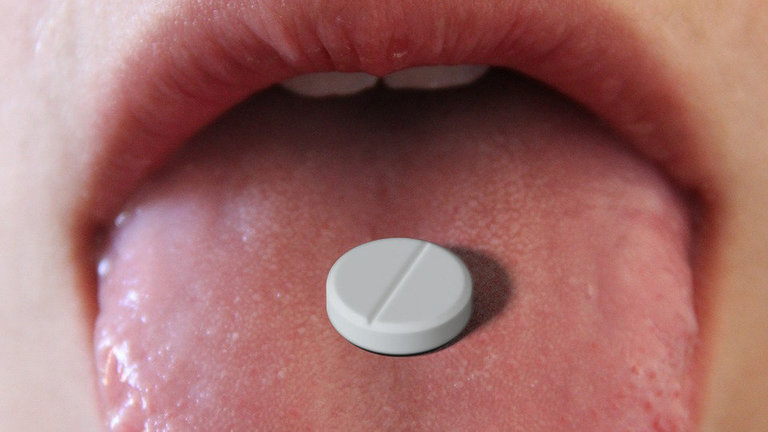 Una persona con una pastilla en la lengua. PIXABAY