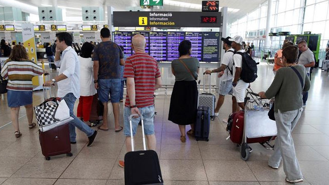 Varios viajeros, en el aeropuerto de El Prat, en Barcelona. Alejandro García (Efe)