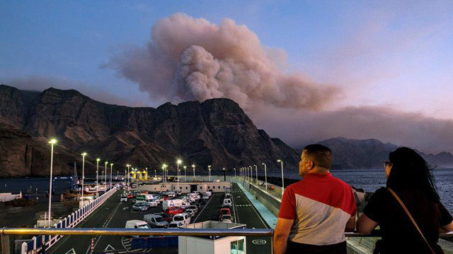 Una columna de humo vista desde el muelle de Agaete, en Gran Canaria. ÁNGEL MEDINA G. (EFE)