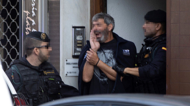 Agentes de la Guardia Civil acompañan a uno de los nueve detenidos durante el registro de un domicilio en Sabadell. ENRIC FONTCUBERTA