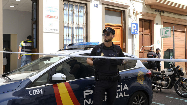 Un policía vigila la entrada al edificio del centro de Las Palmas donde ocurrieron los hechos. ÁNGEL MEDINA (EFE)