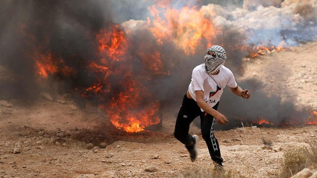 Un manifestante lanza una piedra contra tropas israelíes durante un encontronazo en la ciudad cisjordana de Hebrón. ABED AL HASHLAMOUN