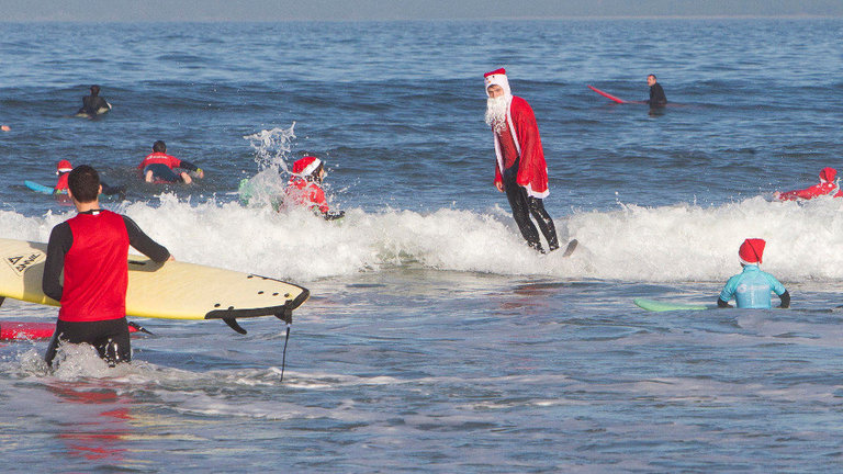 Un año más los Papá Noeles surferos se han dado cita en la playa de Patos en Nigrán. SALVADOR SAS (EFE) (2)