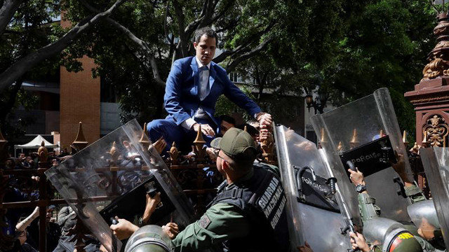 Guaidó trepa una reja en un intento por ingresar a la sede de la Asamblea Naciona. RAYNER PEÑA