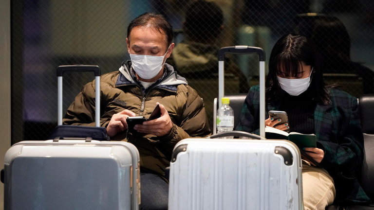 Viajeros esperan con máscaras en un aeropuerto de China. EFE