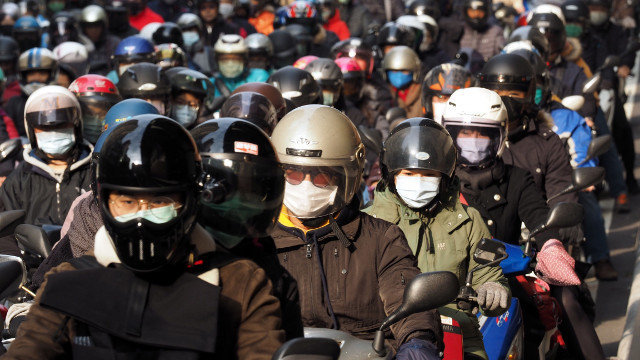 Motoristas taiwaneses conducen con máscaras faciais, este xoves en Taipei. EFE