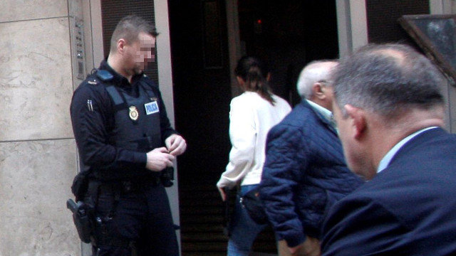 Un agente, ante el portal de la vivienda de Gijón en la que se produjo el crimen machista. EFE