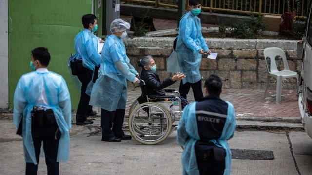 Varios sanitarios trasladan a una mujer en China.JEROME (Efe)