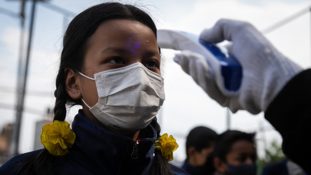 Un médico le toma la temperatura a una niña en Nepal. EFE