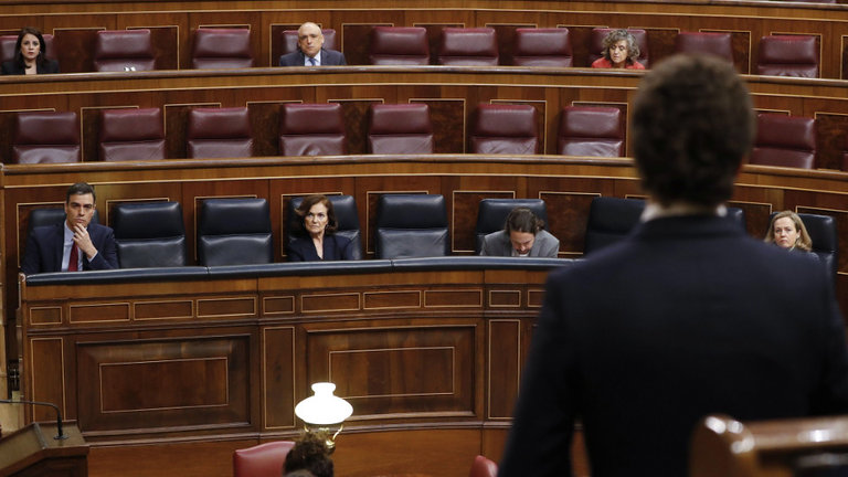 Pedro Sánchez (i) escucha al líder de la oposición, Pablo Casado (de espaldas), durante la sesión de control. EFE