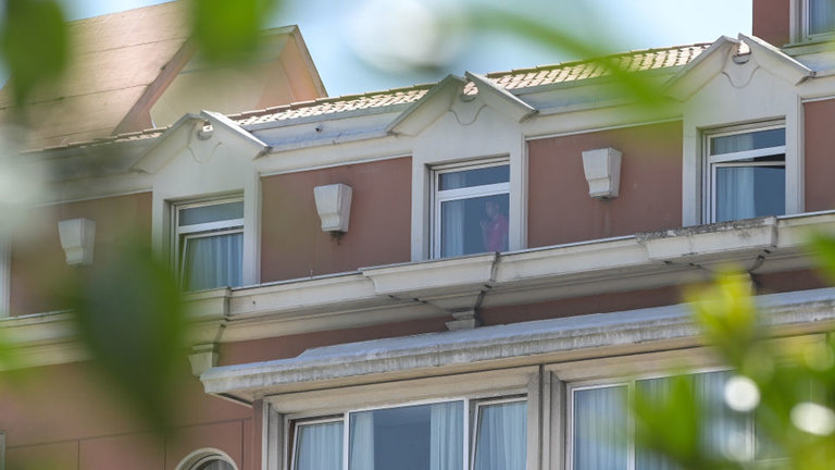 Una persona mira por la ventana donde se alojan los jugadores del Fuenlabrada. EUROPA PRESS