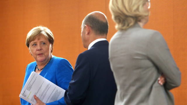Angela Merkel hablando esta mañana con el ministro de finanzas Olaf Scholz. EFE