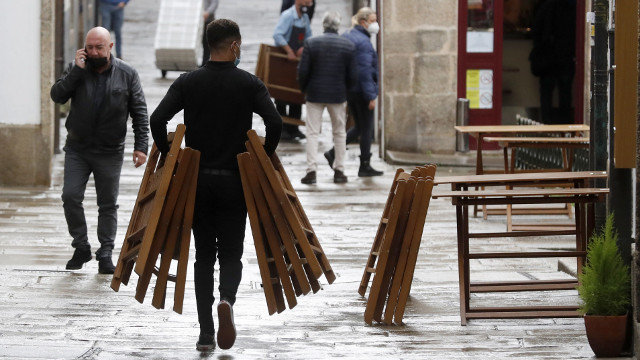 Un camareiro recolle unha terraza nunha rúa de Santiago de Compostela. LAVANDEIRA JR (EFE)