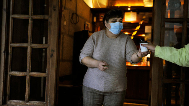 Unha traballadora dun mesón da Praza Maior do Carballiño serve un café para levar pola fiestra. EUROPA PRESS