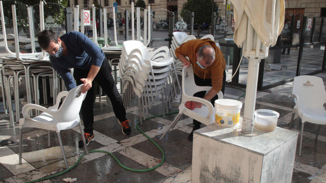 Dos hosteleros preparan su terraza en Granada. EFE