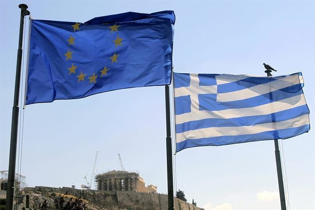 Una bandera griega y una de la Unión Europea ondean este martes junto al Acrópolis de Atenas