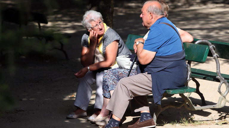 Un grupo de xubilados sentados nun banco. AEP