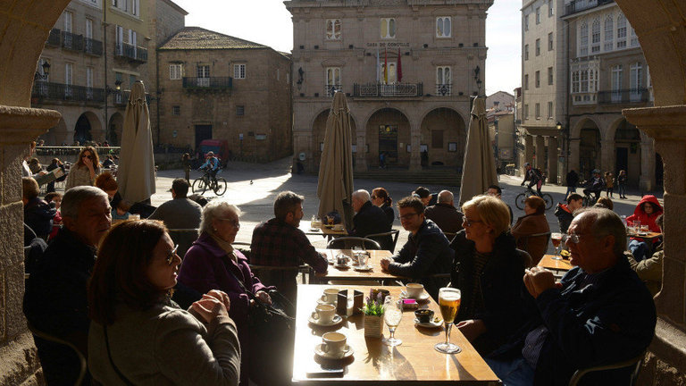 Varias personas disfrutan del tiempo seco y soleado de estos días en una terraza de Ourense. EFE