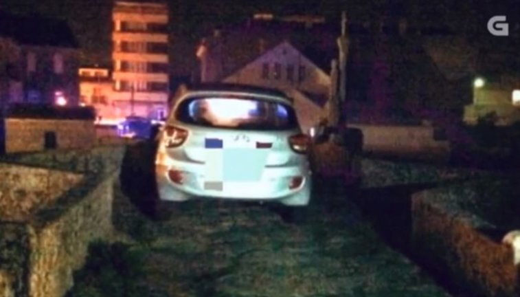 Imagen difundida por la TVG del coche que se quedaba atascado en un puente en Baiona cuando intentaba eludir un control. CRTVG