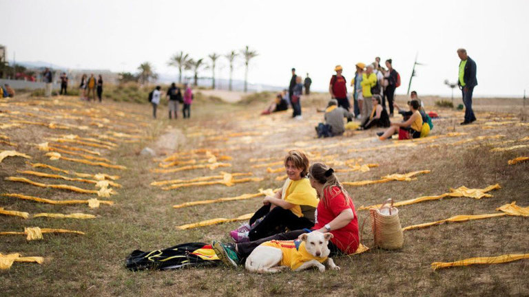 Despliegue de bufandas amarillas en forma de cruz en la playa de Mataró (Barcelona). MARTA PÉREZ (EFE)