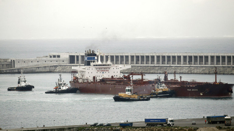 Un petrolero atraca en el puerto exterior de Punta Langosteira con la ayuda de varios remolcadores. EFE