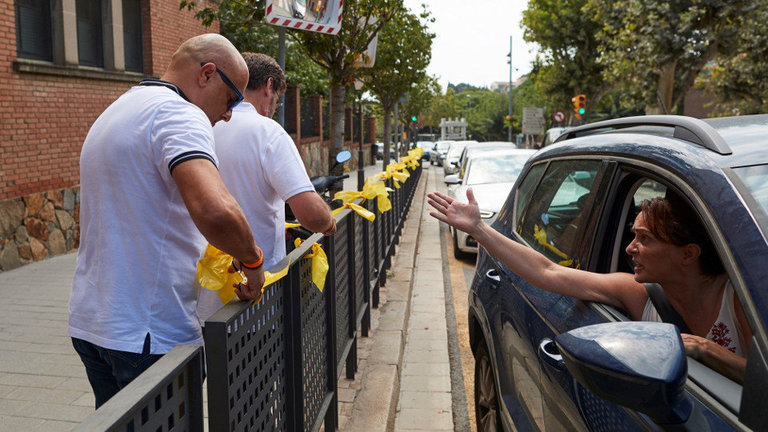 Una mujer increpa a miembros a dos personas que retiraban lazos amarillos en la localidad de Alella (Barcelona). ALEJANDRO GARCÍA (EFE)
