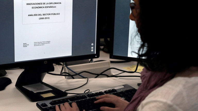 Una mujer consulta en Internet la tesis del presidente del Gobierno. EFE