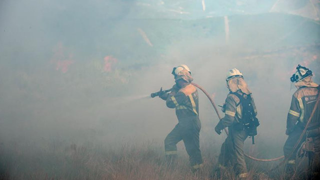 Brigadistas, durante la extinción del incendio en Cualedro. BRAIS LORENZO (Efe)