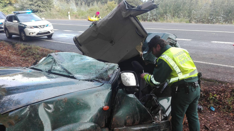 Un guardia revisa el coche siniestrado en Portomarín. GUARDIA CIVIL DE TRÁFICO