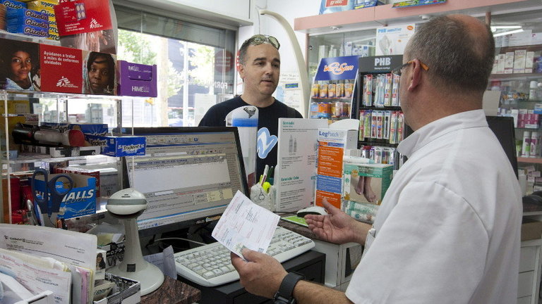 Un farmacéutico atiende a un cliente. JULIÁN MARTÍN (EFE)