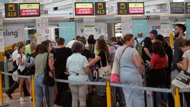 Los viajeros se aglutinan en largas colas para reclamar una solución a Vueling tras la cancelación de sus vuelos.ALEJANDRO GARCÍA