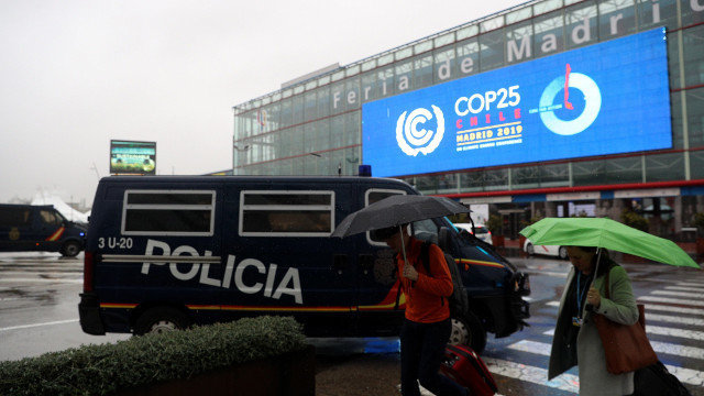 Vehículos policiais estacionados nunha das entradas ao Cume do Clima que arrinca este luns en Madrid. JAVIER LIZÓN (EFE)