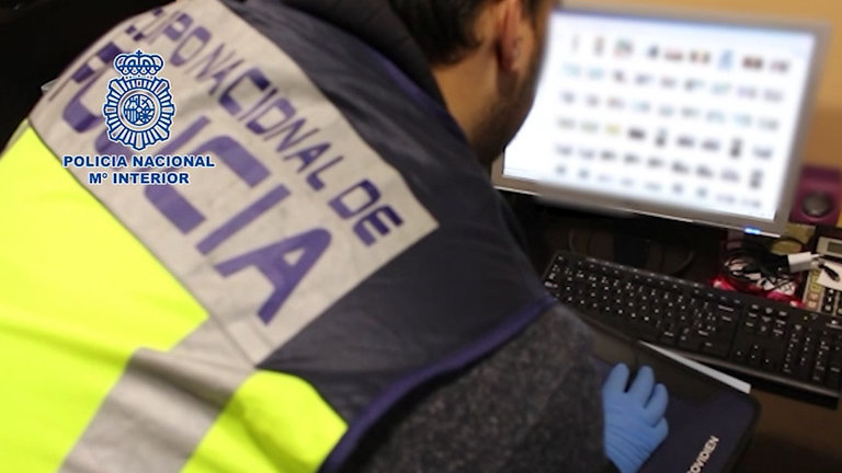 Un agente de la Policía Nacional frente a un ordenador con material pedófilo en una operación anterior. AEP