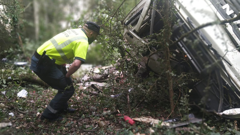 Efectivos de la Guardia Civil inspeccionan los restos del camión siniestrado en Portomarín. EP