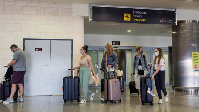 Vairos turistas llegan al aeropuerto de Menorca.DAVID ARQUIMBAU SINTES (Efe)