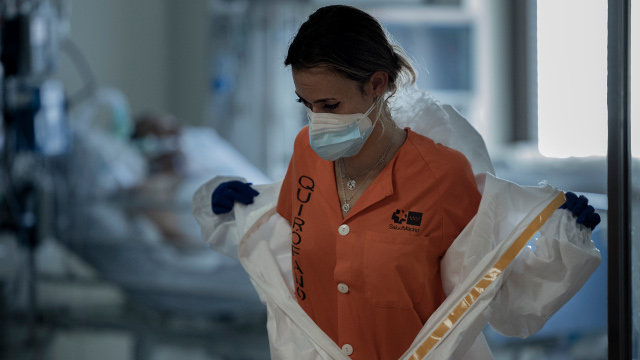 Una sanitaria se quita el traje de protección en un hospital de Madrid. EP