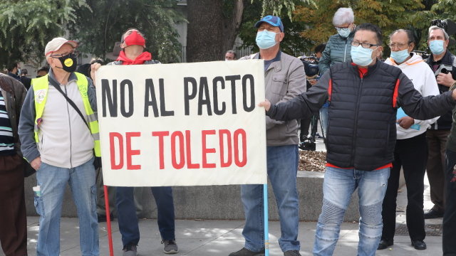 Un grupo de personas sostiene una pancarta contra el Pacto de Toledo en las inmediaciones del Congreso . EFE